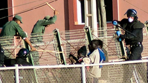 Agentes de la Guardia Civil y las fuerzas auxiliares marroquíes tratan de impedir que que varias personas migrantes salten la valla de Melilla.- CAMINANDO FRONTERAS