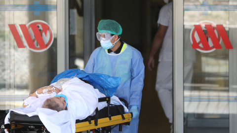 Un enfermero lleva a un paciente al hospital Arnau de Vilanova. /Reuters Un enfermero lleva a un paciente al hospital Arnau de Vilanova. /Reuters