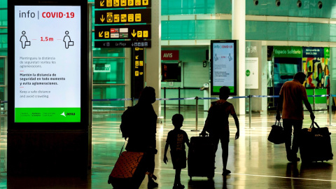 Viajeros con máscaras sanitarias caminan por la Terminal 1 del aeropuerto Josep Tarradelles - El Prat, en Barcelona. EFE/ Enric Fontcuberta Viajeros con máscaras sanitarias caminan por la Terminal 1 del aeropuerto Josep Tarradelles - El Prat, en Barcelona. EFE/ Enric Fontcuberta