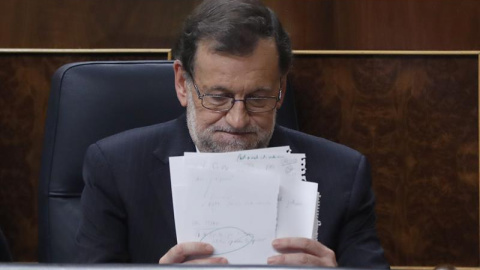 El presidente del Gobierno en funciones y candidato del PP, Mariano Rajoy, coloca unos papeles durante la sesión de la tarde de la segunda jornada del debate de investidura, hoy en el Congreso de los Diputados. EFE/Chema Moya