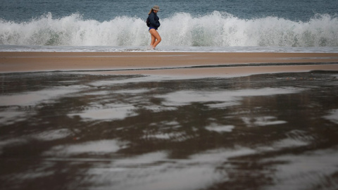 Una mujer pasea este martes por la orilla de la playa de La Concha de San Sebastián. EFE Una mujer pasea este martes por la orilla de la playa de La Concha de San Sebastián. EFE