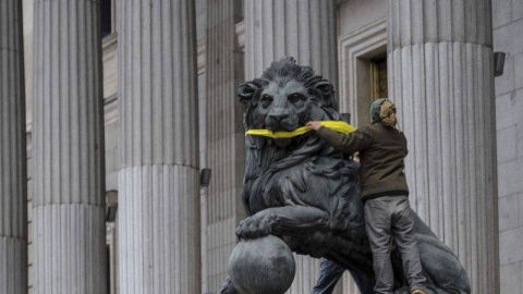 Una activista de Greenpeace amordaza los leones del Congreso de los Diputados. - Foto: EFE Una activista de Greenpeace amordaza los leones del Congreso de los Diputados. - Foto: EFE