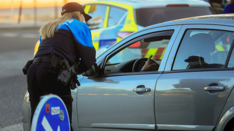 Una policía local informa de las nuevas limitaciones a un conductor, este lunes, en la primera jornada de restricciones aplicadas a las áreas sanitarias de Miguel Servet y Doctor Trueta de la localidad madrileña de Alcorcón. EFE/Fernando Alvarado Una policía local informa de las nuevas limitaciones a un conductor, este lunes, en la primera jornada de restricciones aplicadas a las áreas sanitarias de Miguel Servet y Doctor Trueta de la localidad madrileña de Alcorcón. EFE/Fernando Alvarado