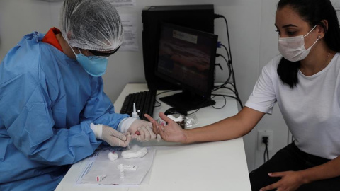 Una sanitaria realiza un analítica de sangre para detectar un nuevo positivo en Brasil. EFE Una sanitaria realiza un analítica de sangre para detectar un nuevo positivo en Brasil. EFE