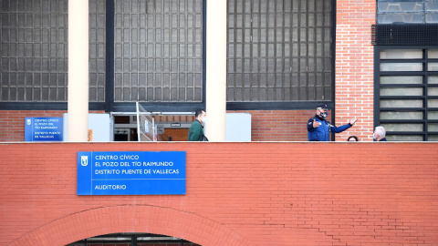 La Comunidad continúa con los test de antígenos en Vallecas a los vecinos de las zonas de Pozo del Tío Raimundo y Numancia. En la imagen, un agente de policía habla con una de las personas que espera en el Centro Cultural del Tio Raimundo para realiza