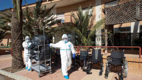 Trabajadoras equipadas con trajes de protección, durante las labores de desinfección de la residencia de ancianos de la Purísima de Totana. - EFE