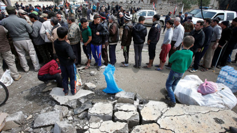 Civiles reciben paquetes de ayuda humanitaria de una organización humanitaria chií en el distrito de Al Guizlane, mientras continúa la batalla en Mosul REUTERS/Youssef Boudlal