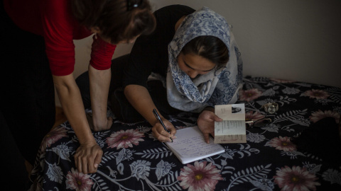 Dos de las chicas afganas revisan su documentación de asilo.- JAIRO VARGAS