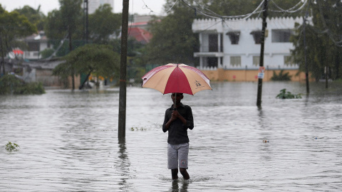 Un hombre sujeta un paraguas en una inundación en Colombo, Sri Lanka./ REUTERS Un hombre sujeta un paraguas en una inundación en Colombo, Sri Lanka./ REUTERS