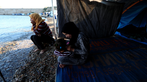 Faten (i), procedente de Siria, se sienta a la orilla del mar junto a su nuera, cerca de su tienda en el campo de refugiados de Souda, en la isla de Chios. "Está tardando demasiado. Esta lentitud para traer a toda la familia me asusta", dice Faten. "No t Faten (i), procedente de Siria, se sienta a la orilla del mar junto a su nuera, cerca de su tienda en el campo de refugiados de Souda, en la isla de Chios. "Está tardando demasiado. Esta lentitud para traer a toda la familia me asusta", dice Faten. "No t