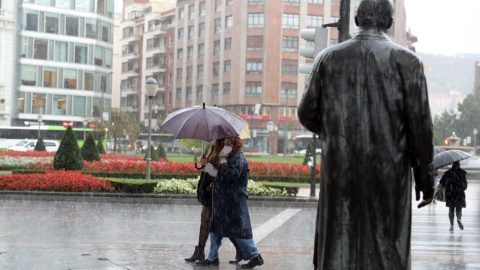 Varias personas se protegen de la fuerte lluvia en Bilbao. EFE/LUIS TEJIDO/Archivo Varias personas se protegen de la fuerte lluvia en Bilbao. EFE/LUIS TEJIDO/Archivo
