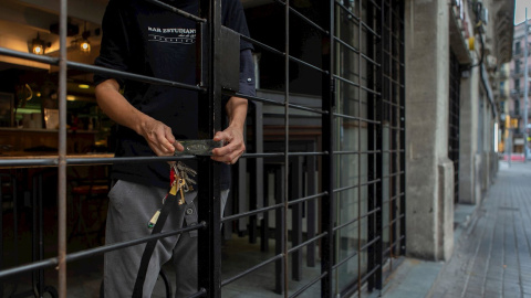 19/10/2020.- Un trabajador de un bar de la Plaza Universidad de Barcelona cierra el local este lunes. / EFE - Enric Fontcuberta 19/10/2020.- Un trabajador de un bar de la Plaza Universidad de Barcelona cierra el local este lunes. / EFE - Enric Fontcuberta