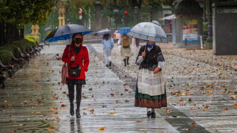 Dos mujeres pasean bajo la lluvia en el paseo de Los Álamos, en el centro de Oviedo, Asturias. EFE/Alberto Morante Dos mujeres pasean bajo la lluvia en el paseo de Los Álamos, en el centro de Oviedo, Asturias. EFE/Alberto Morante