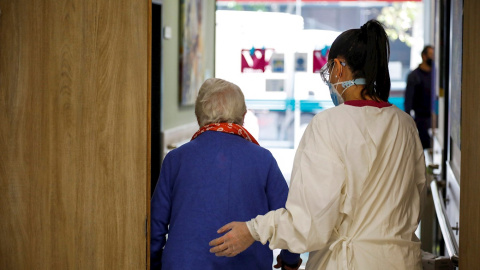 Una trabajadora de la residencia de mayores "Vitalia Canillejas" ayuda a una paciente, este lunes en las instalaciones del centro, en Madrid. / EFE Una trabajadora de la residencia de mayores "Vitalia Canillejas" ayuda a una paciente, este lunes en las instalaciones del centro, en Madrid. / EFE
