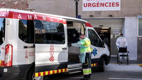 Un sanitarios con equipo de protección especial para evitar contagios de coronavirus, traslada a un paciente de una ambulancia a urgencias del Hospital Clínico de València. EFE/ Biel Aliño