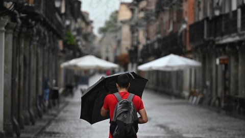 Un hombre se protege de la lluvia que cae en Alcalá de Henares. Un hombre se protege de la lluvia que cae en Alcalá de Henares.