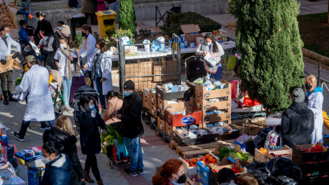 18/01/2022-Personas en riesgo de exclusión acuden a recoger alimentos, en la plaza de San Amaro, a 7 de enero de 2022, en Madrid (España). 18/01/2022-Personas en riesgo de exclusión acuden a recoger alimentos, en la plaza de San Amaro, a 7 de enero de 2022, en Madrid (España).