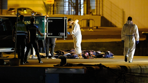 Dos agentes de Policía Portuaria, presencia como los trabajadores de la funeraria se llevan los cadáveres de las tres mujeres migrantes que naufragaron en alta mar en la costa de Lanzarote, en Puerto del Rosario de Fuerteventura, a 25 de agosto de 2021, Dos agentes de Policía Portuaria, presencia como los trabajadores de la funeraria se llevan los cadáveres de las tres mujeres migrantes que naufragaron en alta mar en la costa de Lanzarote, en Puerto del Rosario de Fuerteventura, a 25 de agosto de 2021,