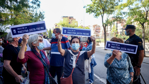 Tres mujeres muestran pancartas en las que figura una placa para la Calle Maestra Justa Freire, en una manifestación para que su nombre vuelva a la que hoy es la calle General Millán-Astray. Tres mujeres muestran pancartas en las que figura una placa para la Calle Maestra Justa Freire, en una manifestación para que su nombre vuelva a la que hoy es la calle General Millán-Astray.