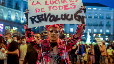 Un manifestante sostiene una pancarta durante una concentración en la Puerta del Sol contra las agresiones a las personas LGTBI