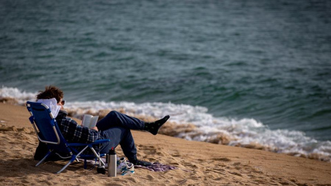 Una persona lee este miércoles en la playa de la Nova Icaria de Barcelona. Una persona lee este miércoles en la playa de la Nova Icaria de Barcelona.