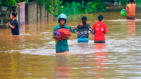 04/04/2021. Un hombre con casco lleva consigo sus pertenencias en un área afectada por las fuertes inundaciones en Indonesia y Timor Oriental. - Reuters 04/04/2021. Un hombre con casco lleva consigo sus pertenencias en un área afectada por las fuertes inundaciones en Indonesia y Timor Oriental. - Reuters