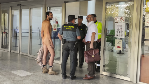 El joven nudista Alejandro Colomar trata de acceder desnudo a los juzgados de València. El joven nudista Alejandro Colomar trata de acceder desnudo a los juzgados de València.