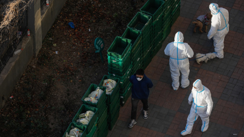 Trabajadores voluntarios pasean perros para los residentes fuera de un edificio de la Unidad con casos confirmados en Beijing, China Trabajadores voluntarios pasean perros para los residentes fuera de un edificio de la Unidad con casos confirmados en Beijing, China