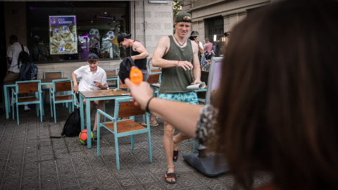 Una dona dispara una pistola d'aigua contra uns turistes en un restaurant de menjar ràpid Una dona dispara una pistola d'aigua contra uns turistes en un restaurant de menjar ràpid