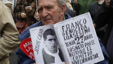 Un hombre muestra una foto de una víctima del franquismo. EFE/Paco Campos Un hombre muestra una foto de una víctima del franquismo. EFE/Paco Campos