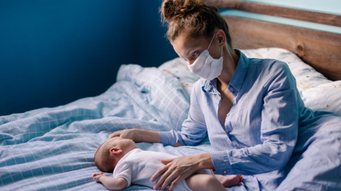 Imatge d'arxiu d'una mare amb mascareta i el seu nadó. Imatge d'arxiu d'una mare amb mascareta i el seu nadó.