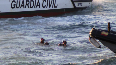 Miembros del Grupo Especial de Actividades Subacuáticas (GEAS) de la Guardia Civil sacan del agua el cuerpo de un inmigrante subsahariano que ha fallecido ahogado tras ser abandonado, junto a otros once inmigrantes, por seis motos de agua que los transpo Miembros del Grupo Especial de Actividades Subacuáticas (GEAS) de la Guardia Civil sacan del agua el cuerpo de un inmigrante subsahariano que ha fallecido ahogado tras ser abandonado, junto a otros once inmigrantes, por seis motos de agua que los transpo