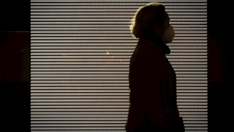 Imagen de una mujer con mascarilla paseando Imagen de una mujer con mascarilla paseando