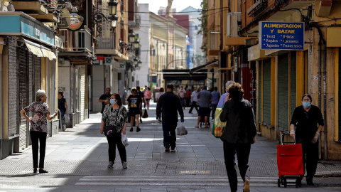 Ciudadanos con mascarillas paseando por una calle de València. /EFE Ciudadanos con mascarillas paseando por una calle de València. /EFE