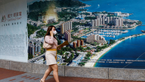 Una mujer pasa junto a un anuncio de Emerald Bay, una de las promociones de China Evergrande, en Hong Kong. REUTERS/Tyrone Siu