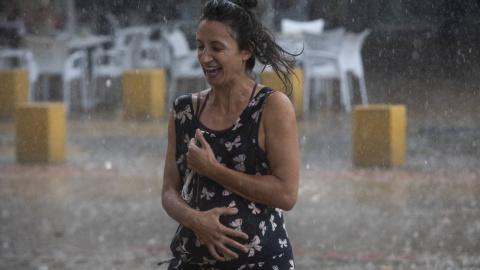 Una mujer corre bajo la lluvia en la Alameda de Hércules (Sevilla) a 14 de septiembre de 2021. Una mujer corre bajo la lluvia en la Alameda de Hércules (Sevilla) a 14 de septiembre de 2021.