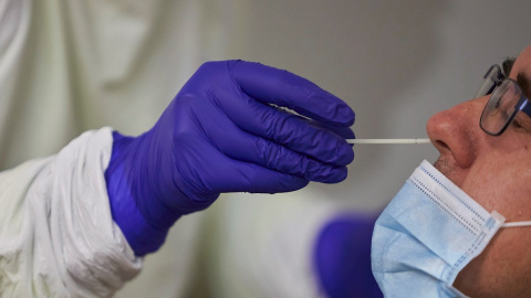 Un sanitario realiza una prueba PCR. Un sanitario realiza una prueba PCR.