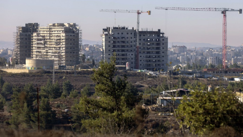 Nuevos edificios de apartamentos en construcción en el asentamiento de Beit El en la ocupada Cisjordania con la ciudad palestina de Ramallah al fondo. Nuevos edificios de apartamentos en construcción en el asentamiento de Beit El en la ocupada Cisjordania con la ciudad palestina de Ramallah al fondo.
