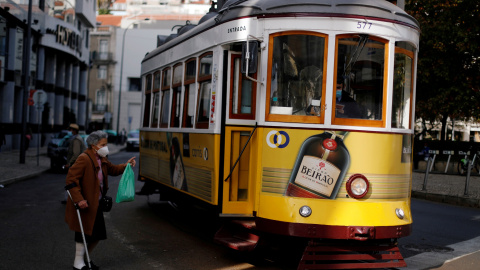 Una mujer conversa con el conductor de un tranvía en Lisboa, Portugal.