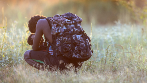 Un migrante haitiano exhausto lleva a su hijo en brazos en río Bravo (Texas). Un migrante haitiano exhausto lleva a su hijo en brazos en río Bravo (Texas).