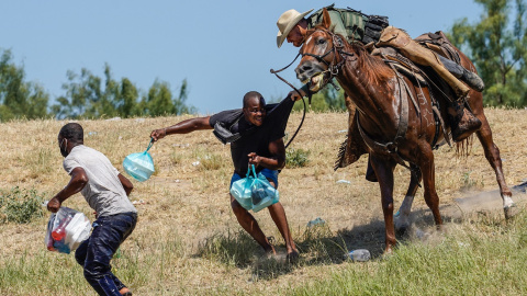 Un agente de la patrulla fronteriza de Estados Unidos a caballo intenta detener a dos migrantes haitianos en el río Grande (Texas). Un agente de la patrulla fronteriza de Estados Unidos a caballo intenta detener a dos migrantes haitianos en el río Grande (Texas).