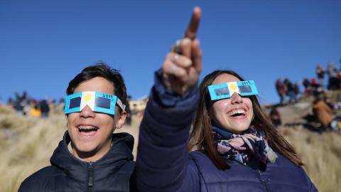 Dos niños con anteojos protectores miran el sol antes del eclipse solar total este martes, en Merlo, San Luis (Argentina). EFE
