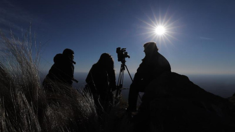 Espectadores al filo de la montaña, observan el sol durante el eclipse solar total en la ciudad de Merlo, San Luis (Argentina). EFE