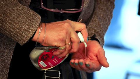Una mujer se desinfecta las manos con gel hidroalcohólico.