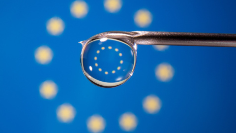 La bandera de la UE se refleja en la gota de una jeringuilla. La bandera de la UE se refleja en la gota de una jeringuilla.
