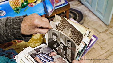 Una mujer muestra unas fotografías familiares. La radiación se extiende por un área de unos 150.000 kilómetros cuadrados. / FERRAN BARBER