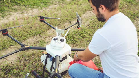 Un agricultor prepara un dron para irrigación de cultivos, una de las innovaciones más importantes de los últimos años en el sector agroalimentario.