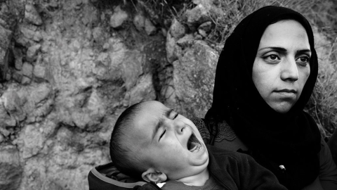 Una madre con su hijo en los brazos tras alcanzar la costa griega.