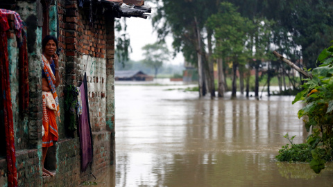 Una mujer observa los efectos de la inundación desde la puerta de su casa, en la zona de Janakpur, en Nepal. REUTERS/Navesh Chitrakar