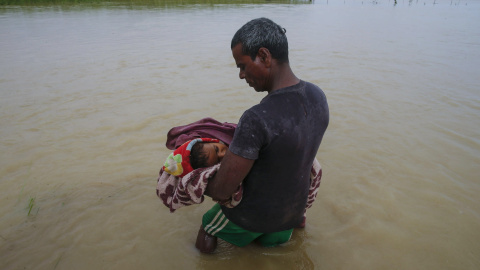 Un nepalí traslada el cadáver de un niño muerto por las inundaciones por el país. EFE / EPA / NARENDRA SHRESTHA